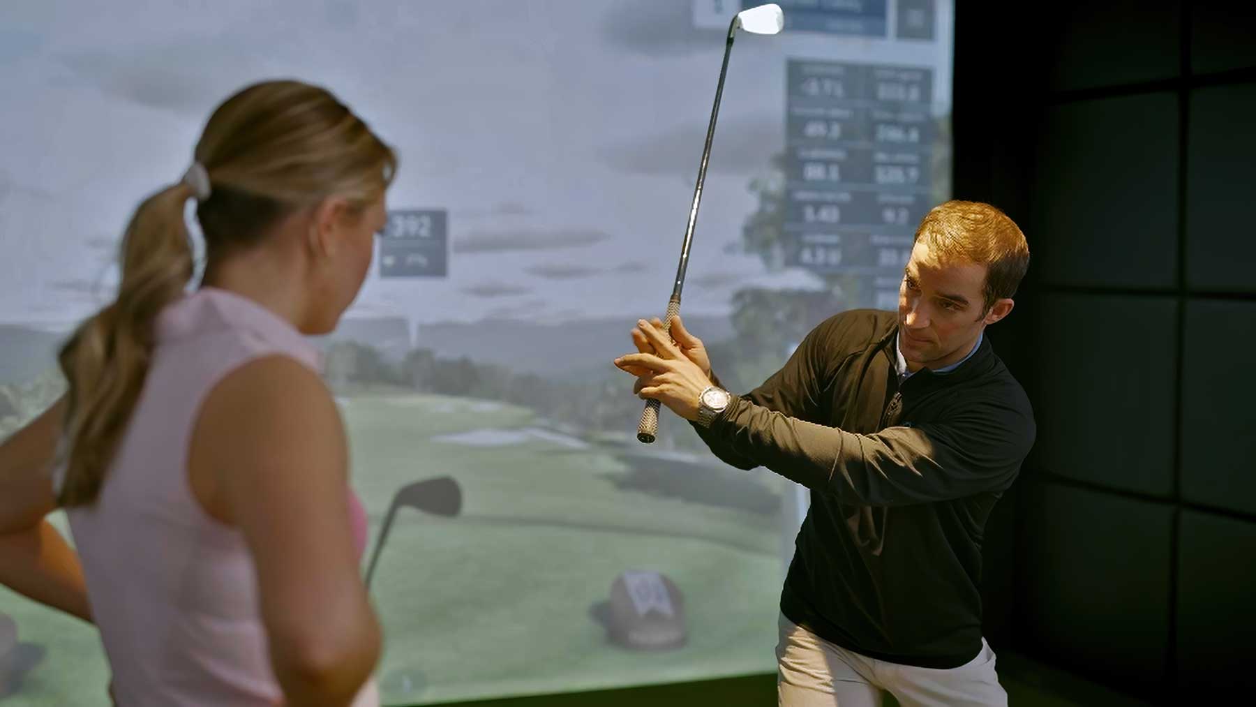 coach demonstrating grip & back swing to junior golfer